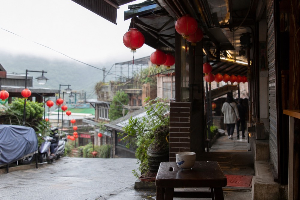 Red paper lanterns hanging along a covered shopping lane