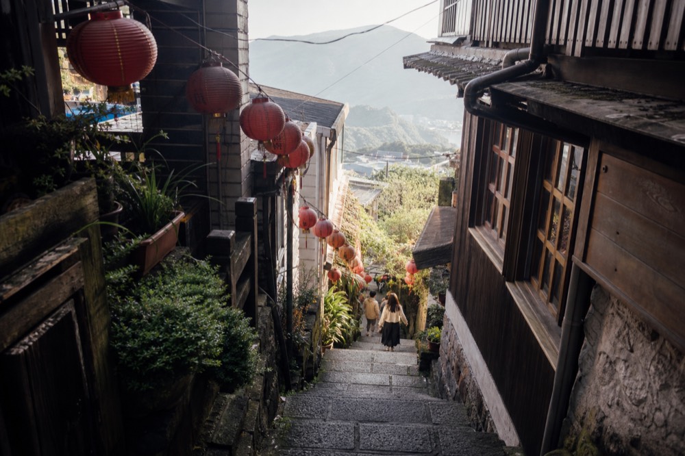 A steep lane of stone steps climbing between old wooden buildings on a hillside