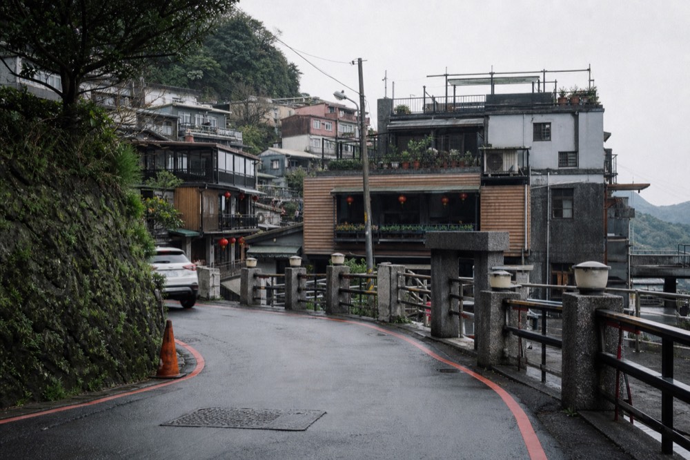 A narrow mountain street with stone walls curving along a hillside