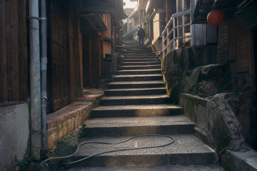 Early morning light on empty stone steps between old wooden buildings