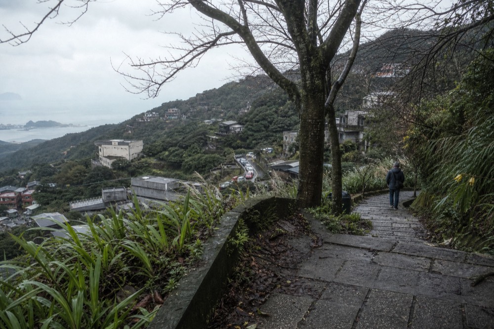 A steep stepped lane between old buildings under overcast winter light