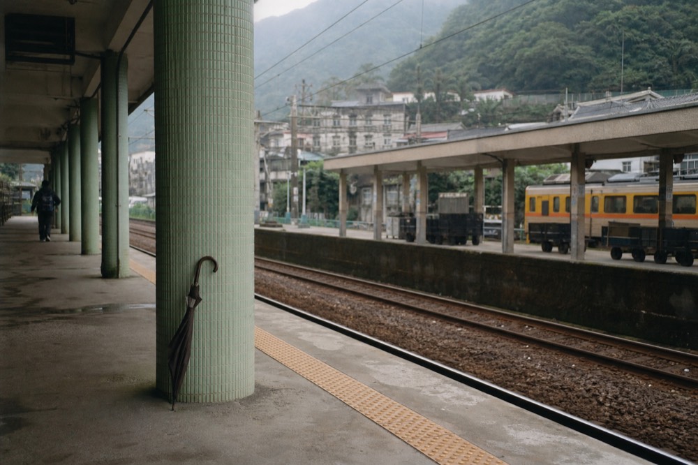 A railway platform beside a small town station in the hills