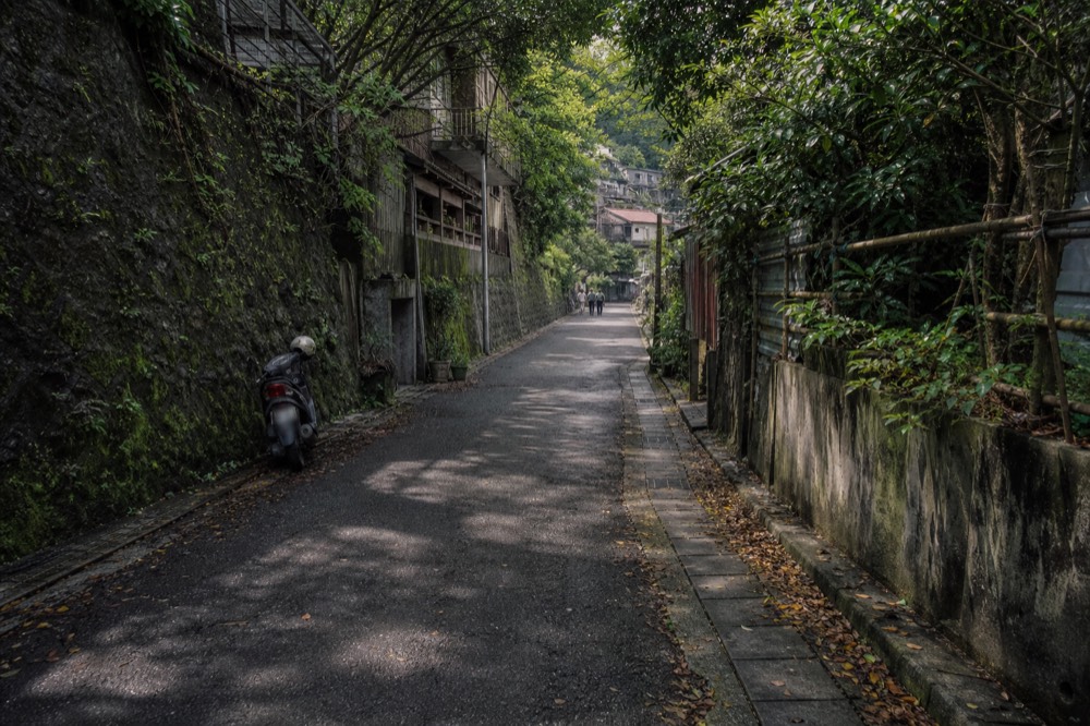 A flat narrow lane between old walls, quiet and empty of crowds
