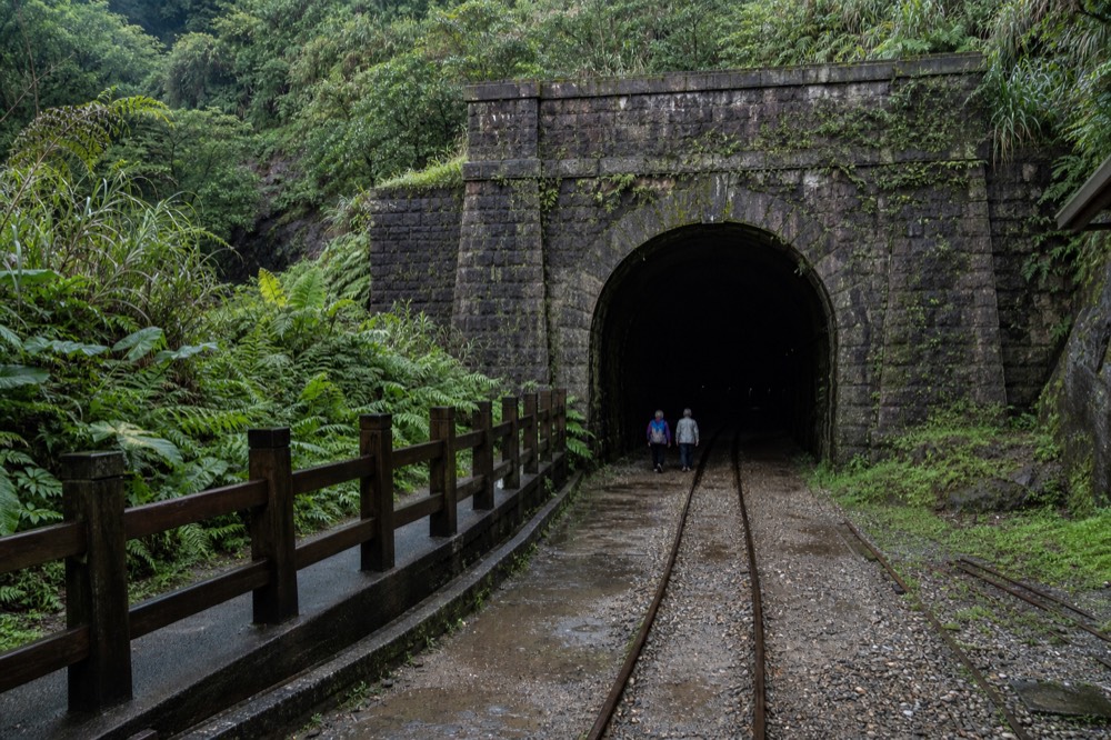 Old stone mine portal set into a green hillside