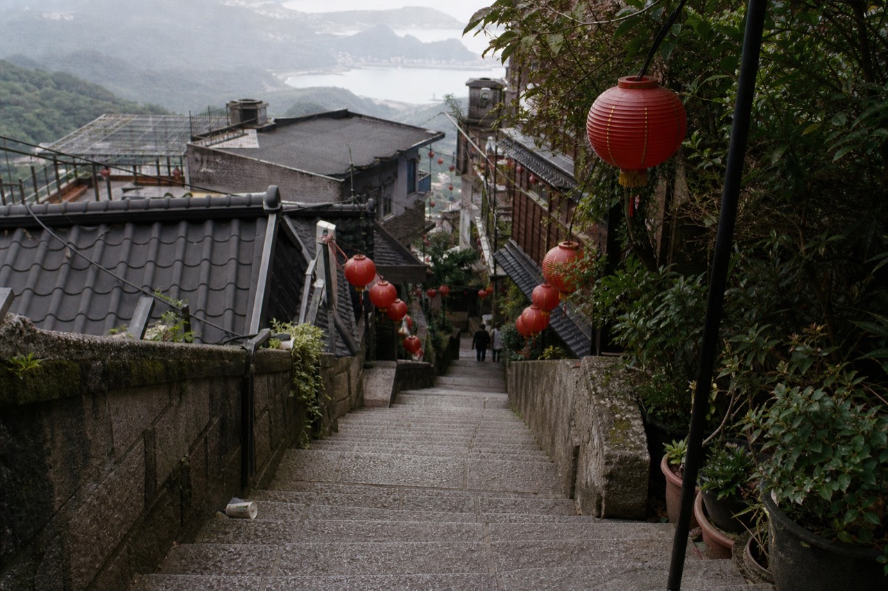 Stone steps and red lanterns along a narrow hillside street in Jiufen