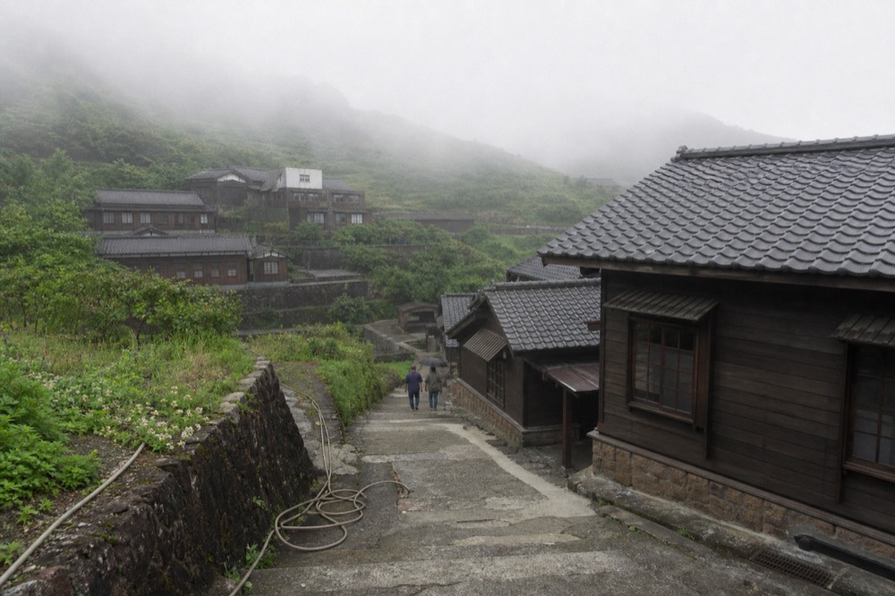 A museum complex of restored Japanese-era mine buildings on a terraced hillside