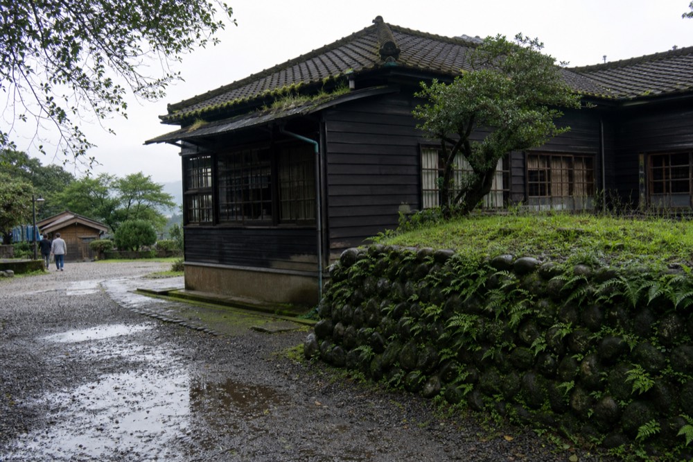 A restored wooden mine office building with tiled roof in a museum grounds