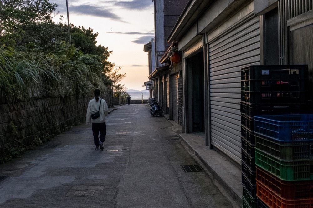 Qingbian Road, the flat former railbed parallel to Jishan Street, with old stone walls and a view of the sea