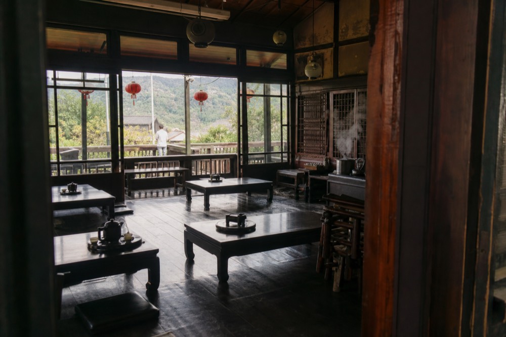 Wooden teahouse interior with low tables and window light