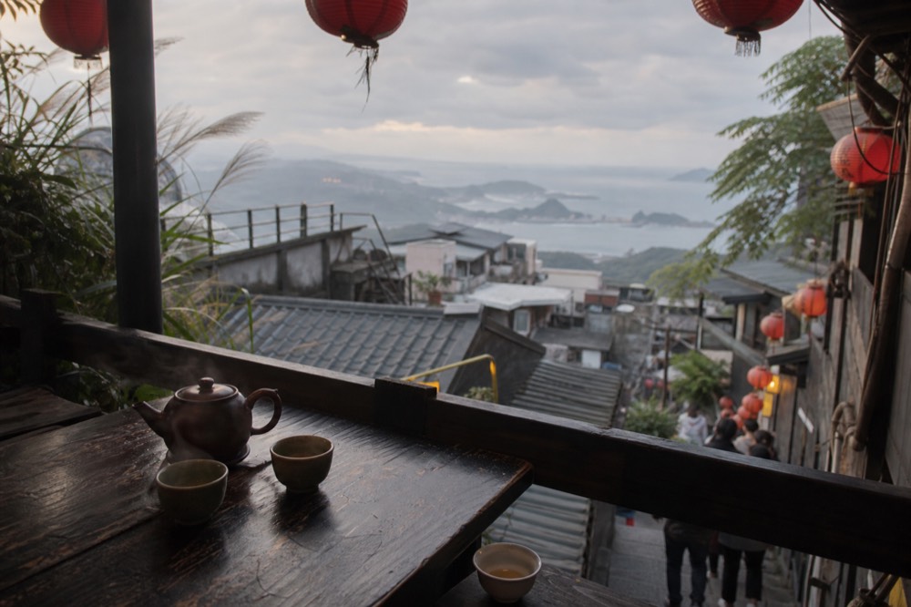 Terrace table with a teapot and cups facing the sea