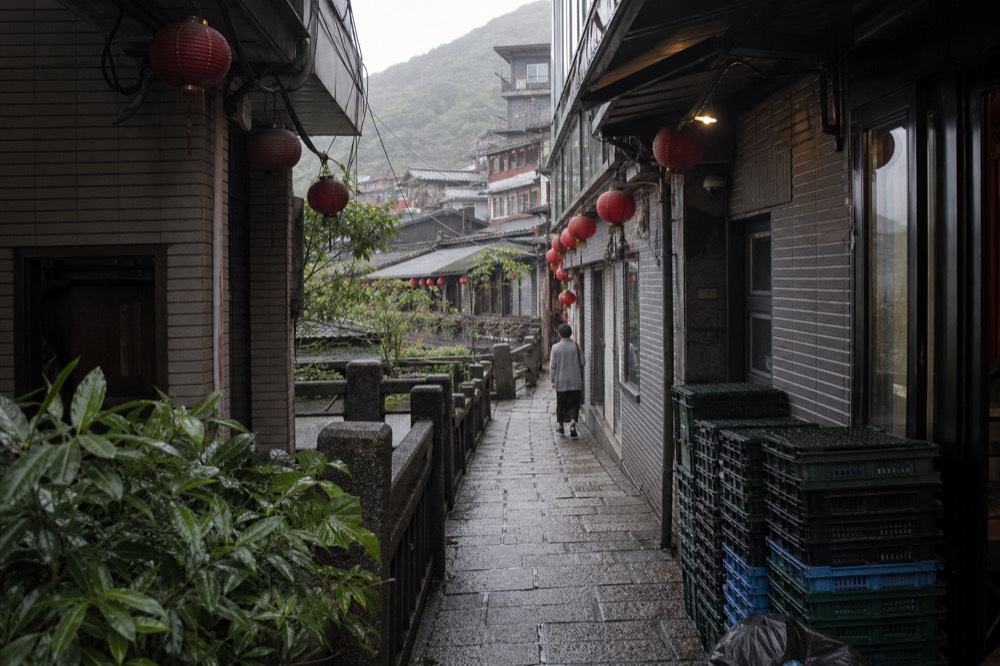 Narrow old street lane with shopfronts and hanging signs