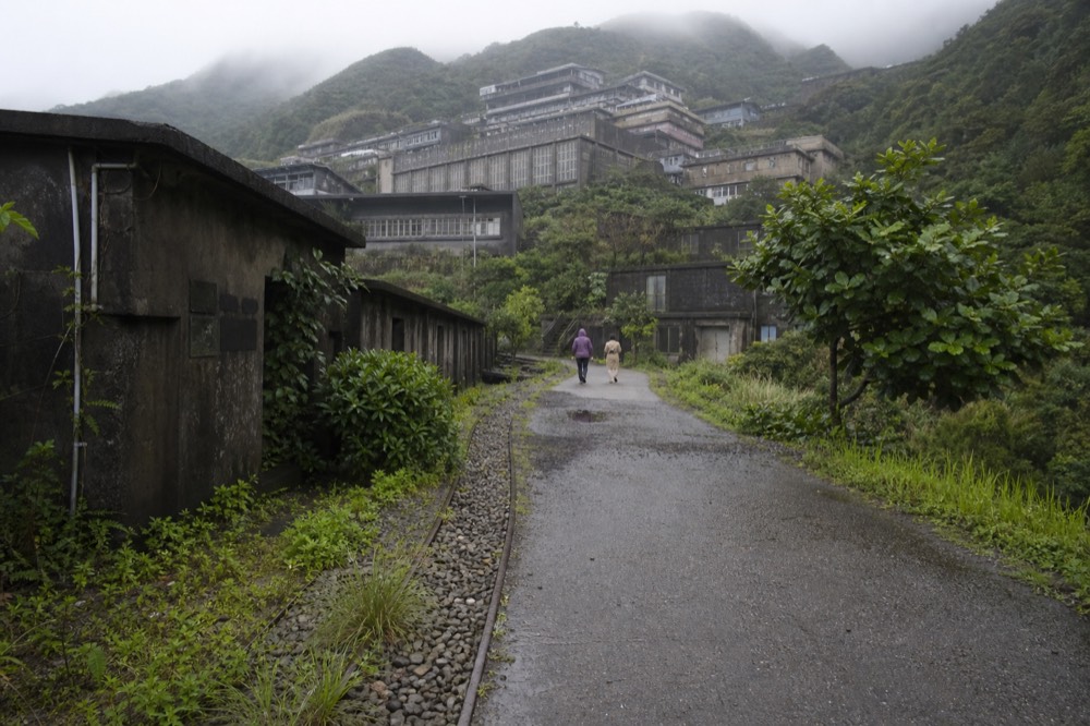 Museum buildings on a hillside above a former mining town, with terraced slopes behind