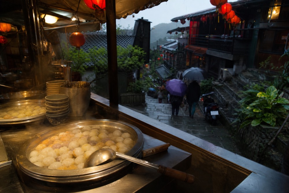 Steaming pots of fish balls and taro balls on a Jiufen food stall counter