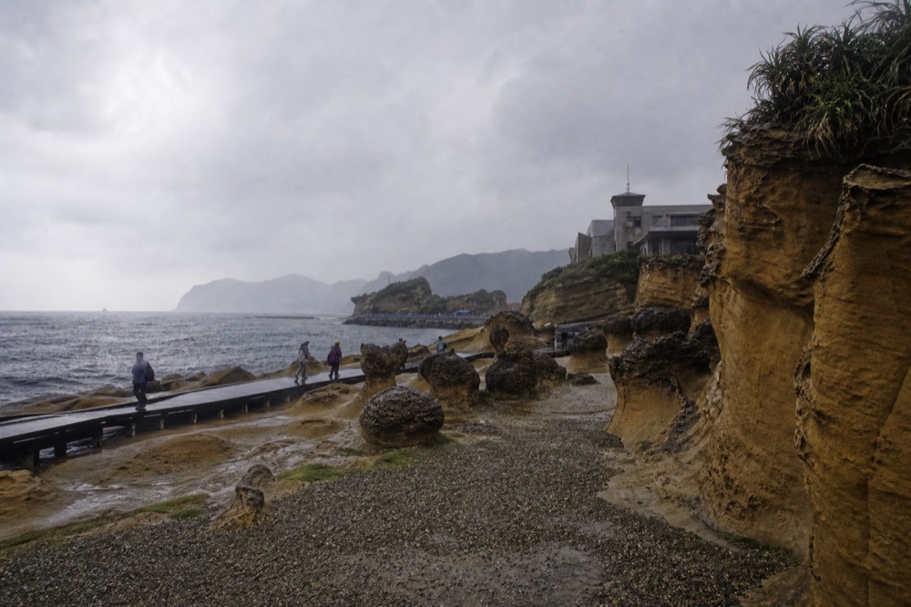 Dramatic clouds and clearing light over a rock-strewn cape and open sea